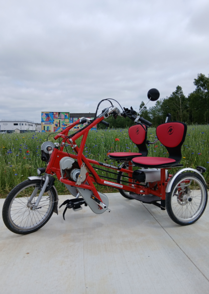 Vélo tandem adapté aux personnes à mobilité réduite, avec sièges confortables et design rouge.