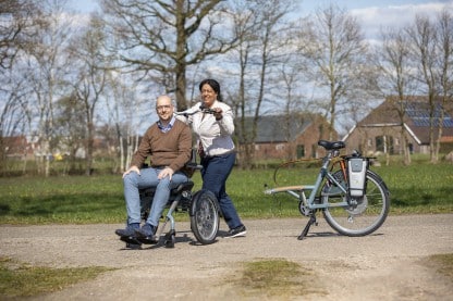 Vélo avec fauteuil roulant devant Opair Van Raam