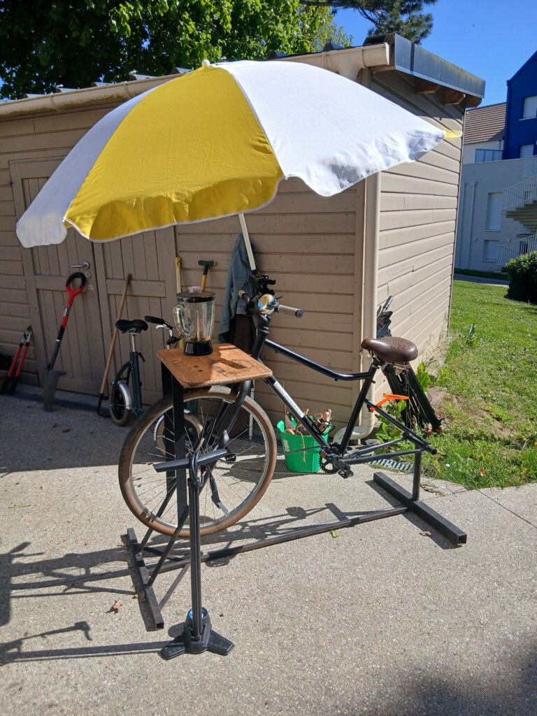 Vélo sur un support avec parasol, outil de service pour la vente et entretien de vélos à Roulez JEUnesse Loisirs.