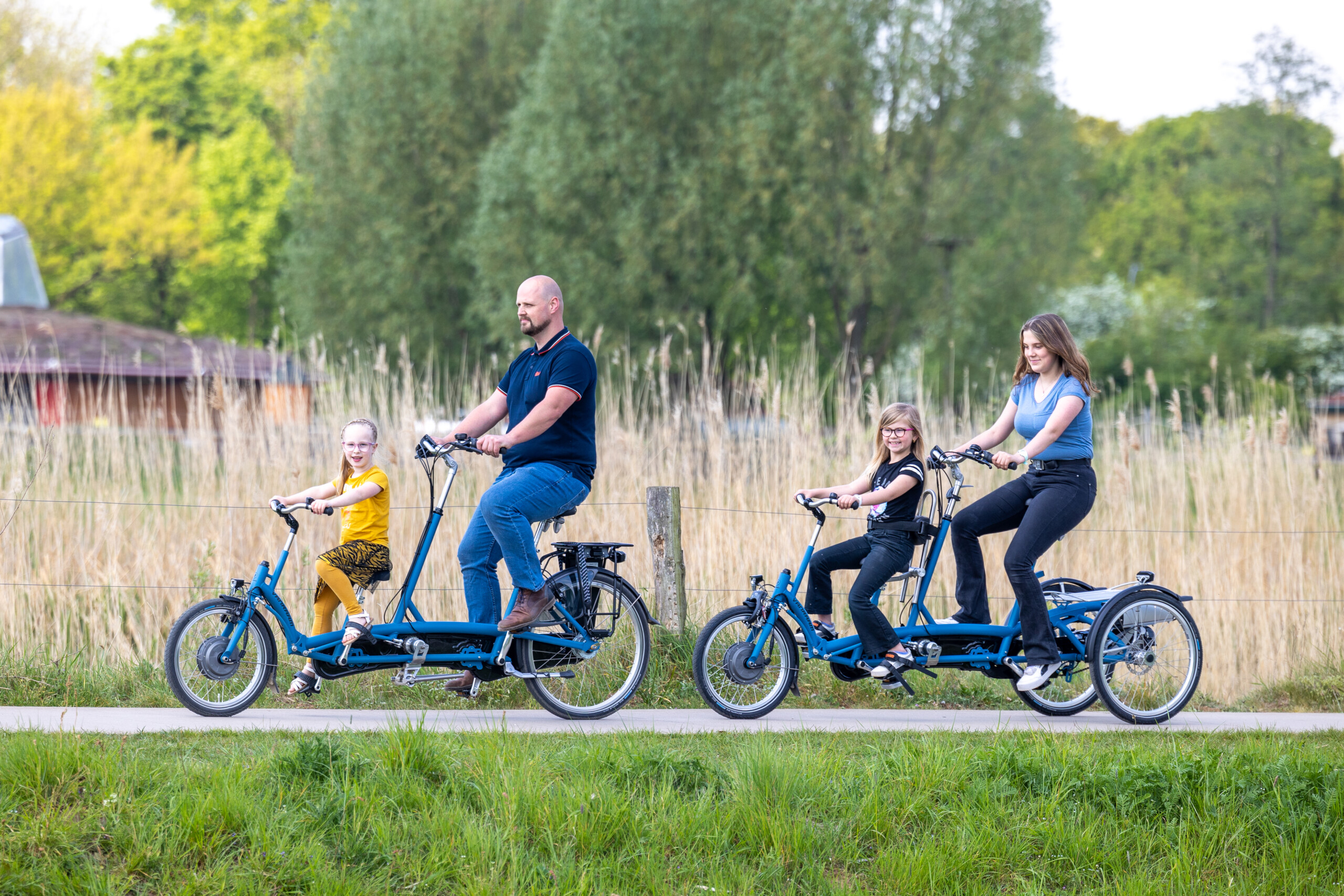 Une famille roule ensemble sur des vélos adaptés, profitant d'une sortie en plein air.