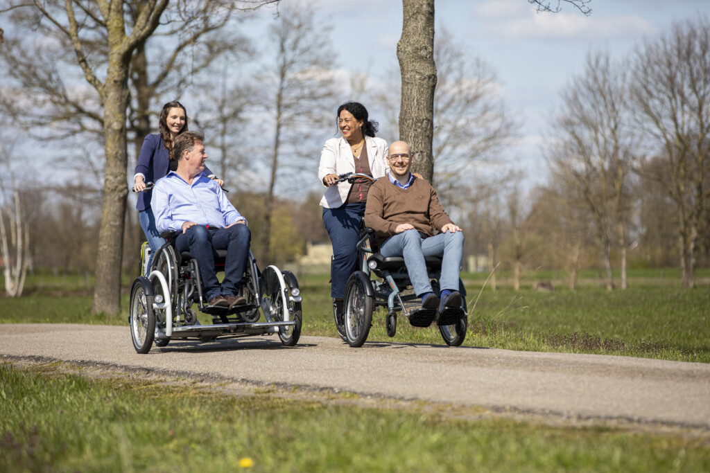 Quatre personnes sur des vélos adaptés, souriantes, profitant d'une balade en plein air.