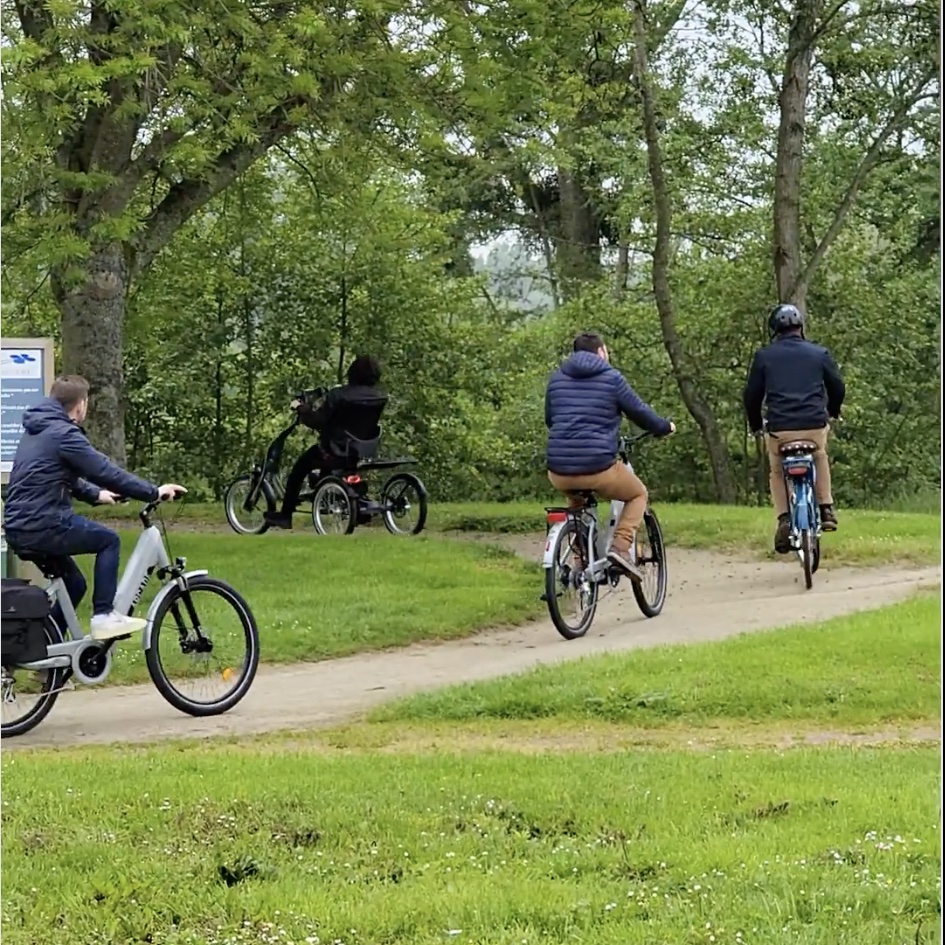 Groupe de cyclistes utilisant des vélos adaptés lors d'une balade en plein air.